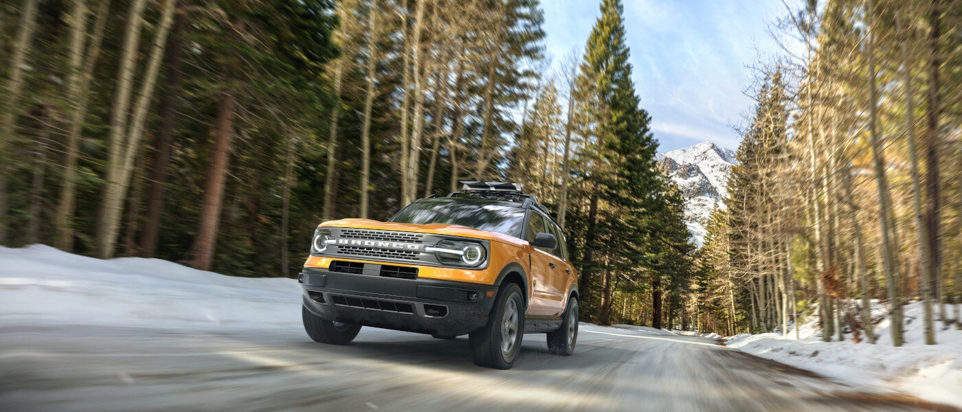 2025 Ford Bronco driving in snowy mountain forest